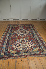 Antique Caucasian Shirvan rug corner, geometric patterns with wear in wine red, ivory, and sky blue.