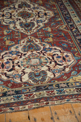 Intricate geometric border patterns and visible wear on an antique Shirvan carpet.