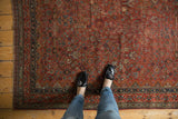 Traditional geometric floral motifs in cherry red, navy, and ivory on a vintage Qashqai rug.