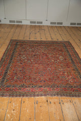 Vintage Qashqai rug with intricate geometric motifs in cherry red and navy blue.