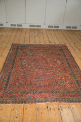 Vintage Qashqai rug's intricate navy, cherry red geometric floral border with secured end.