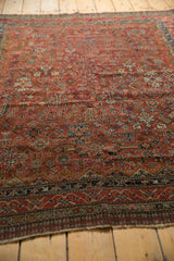 Hand-knotted vintage Qashqai rug end with fringe and red, navy geometric floral borders.