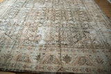 Distressed vintage Mahal carpet corner, showing faded Herati motifs and geometric border.
