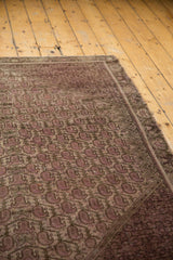 Distressed Malayer rug's repeating booth pattern, pale raspberry and mauve, showing even wear.