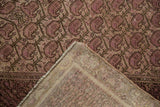 Distressed Malayer rug detail: worn pale raspberry pile, repeating booths, and hand-knotted foundation.