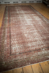 Corner detail of distressed antique Mir Serbend carpet, showcasing textured pile and patterned border.