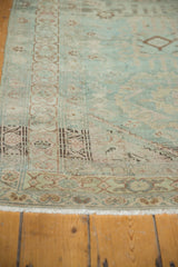 Close-up of distressed vintage Hamadan runner pile with faded teal, ivory, and bronze geometric border.