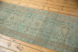 Faded teal aqua blue distressed Hamadan runner with antique ivory medallions and visible even wear.