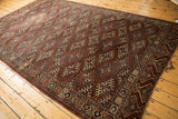 Antique Turkmen carpet corner detail, showing geometric hook gul motifs in aubergine, navy, ivory.