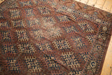 Antique Turkmen carpet's geometric hook gul motifs in aubergine, navy, ivory, with visible foundation.