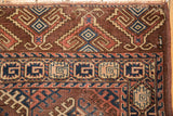 Antique Turkmen rug showing geometric hook gul motifs in aubergine, navy blue, ivory, and fringe.