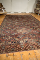 Antique Turkmen carpet corner, geometric gul motifs in aubergine, navy, ivory, with even pile wear.