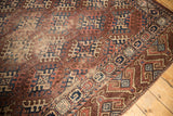 Antique Turkmen carpet corner: geometric hook gul and border, aubergine, navy, ivory, with wear.