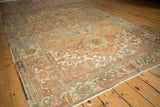 Distressed low pile and traditional geometric border design of the vintage Heriz rug.