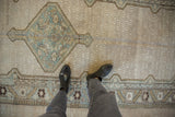 The slate blue diamond medallion and textured ivory field of a vintage distressed Serab rug runner.