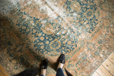 Distressed Kashmar rug showcasing ocean green floral tendrils, faded gold tones, and exposed foundation.