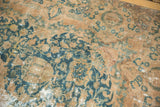Distressed vintage Kashmar carpet, teal floral vines, pictorial motifs, and sand-colored wear.