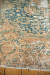 Distressed vintage Kashmar carpet detail, ocean green curvilinear floral tendrils on worn beige.