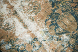 Distressed Kashmar rug pile revealing foundation and faded teal, gold, and beige motifs.