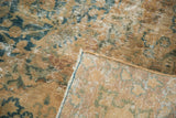 Distressed texture of vintage Kashmar rug, revealing visible foundation and faded teal and gold floral motifs.