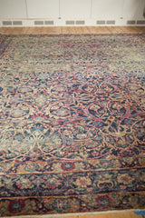 Intricate border of vintage Yezd carpet, showing scrolling vines in navy, cochineal, and ivory.
