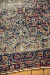 Traditional Yezd rug's scrolling vines, floral border, navy blue, cochineal, and wear.