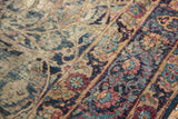 Worn pile of the Vintage Yezd carpet, revealing navy blue scrolling vines, faded ruby tones, and foundation.