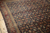 Vintage Fereghan carpet's finely woven wool, showing navy Herati motif and black cherry red border.