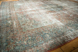 Distressed vintage Kashan carpet corner with faded blush red, sky blue floral border, and prominent foundation.