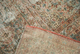 Distressed vintage Kashan carpet showing worn floral pile and hand-knotted foundation.