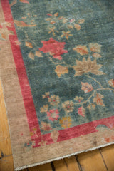 Art Deco rug corner with distressed aqua field, vibrant red border, and visible knot heads.