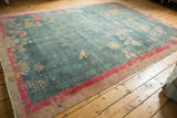 Distressed vintage Art Deco carpet detail: faded aqua blue field, bright pink red floral border.