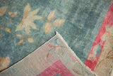 Distressed Art Deco carpet corner, faded aqua field, worn ivory florals, and red-toned foundation.