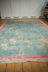 Distressed Art Deco carpet edge shows faded blossomed florals, pink-red border, and foundation wear.