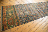 Hand knotted Laristan runner field: dark blue, terracotta, henna plant motif, visible wear.