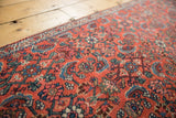 Intricate brick red Herati motif and blue details on vintage Bijar rug pile.