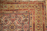 Distressed Malayer rug corner showcasing intricate Herati motif with pale gem green, rust, and navy.