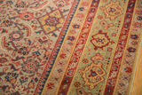 Detail of antique distressed Malayer runner showcasing rust, pale green, and navy borders.