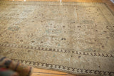 Distressed ivory Tabriz rug corner with pawn border and faded floral motifs.