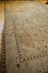 Distressed vintage Tabriz rug corner with beige field, scrolling palmettes, and dark brown pawn motif border.