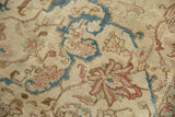 Vintage distressed Tabriz rug detail showing worn pile, visible foundation, and muted floral design.