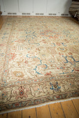 Distressed vintage Tabriz carpet's low pile, showing foundation with sky blue and terra cotta botanical motifs.