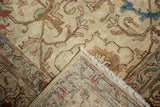 Distressed Tabriz carpet folded corner shows worn pile, woven foundation, and fringe.