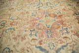 Distressed Persian Tabriz carpet shows ivory, sky blue, and terra cotta floral tendril motifs.