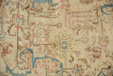 Distressed Persian Tabriz carpet showing faded ivory, blue, and terra cotta curvilinear patterns.