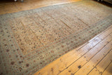 Distressed antique Malayer carpet corner: ivory field, pale sea foam border, visible foundation.