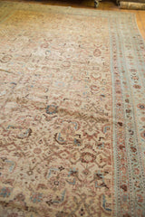 Abrasions and worn Herati pattern on the antique distressed Malayer carpet in muted tones.