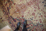 Antique Persian Kermanshah carpet displaying intricate mil fleur patterns, red, blue, and ivory tones.