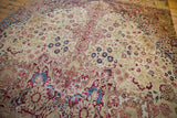 Antique Kermanshah mil fleur carpet showing cochineal red, blue, ivory, and foundation wear.