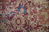 Mil fleur design detail on an antique Persian Kermanshah carpet, cochineal red and sky blue hues.